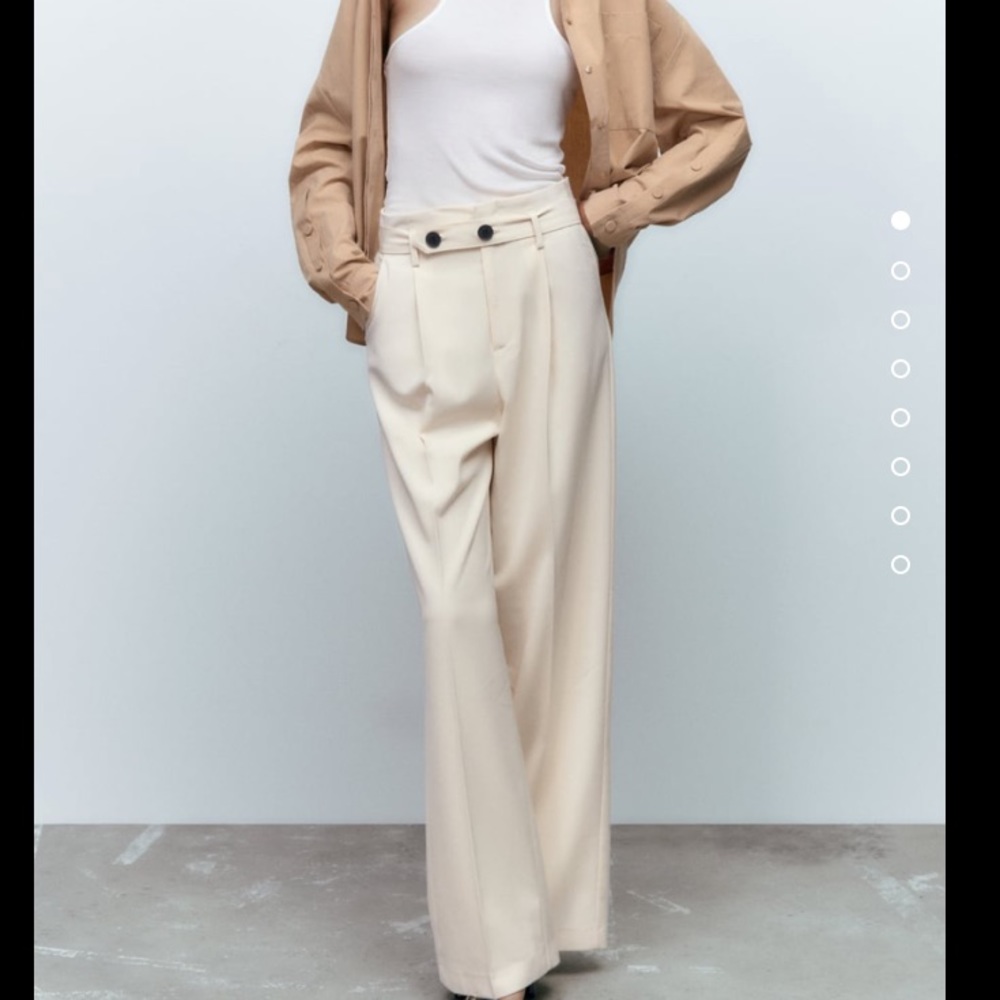 High waisted pants with front pleats and tonal belt with buttons.